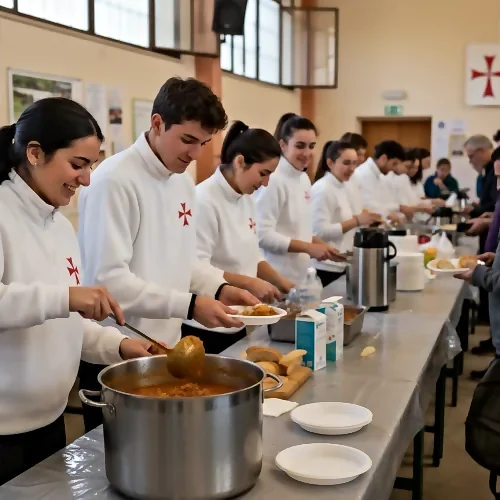 Volontari servono i pasti durante una mensa solidale
